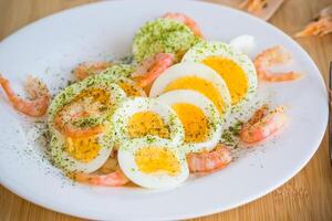 boiled eggs with boiled shrimp in a plate for breakfast photo