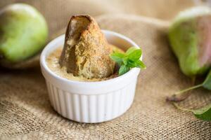 pear baked in curd dough in a small ceramic form photo