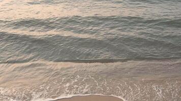 onda spruzzi nel Alba o tramonto su un' tropicale spiaggia. video