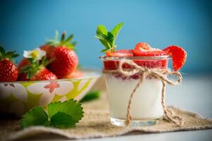 sweet homemade yogurt with strawberry jam and fresh strawberries in a glass cup photo