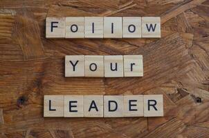 follow your leader text in wooden square photo