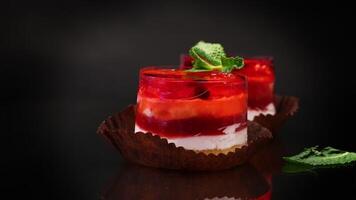 fruit cake with jelly, filled with berries, on a black background. video