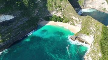 tropical island beach people walking cliff kelingking nusa penida bali aerial 4k video