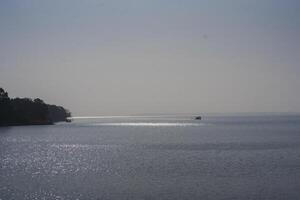 Water and beach on river with sky and trees photo