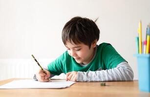 educación concepto,escuela niño utilizando negro color bolígrafo dibujo o dibujar en papel, retrato chico emplazamiento en mesa haciendo deberes en vivo habitacion,niño disfrutar Arte y arte actividad a hogar foto