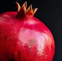 AI generated close up pomegranate isolated on black background photo