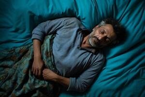 AI generated From an aerial perspective, a man lies in bed under a turquoise blanket photo