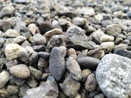 Gray gravel stones for the construction industry. Mound of granite gravel, stones, crushed stone close-up. Rough seamless texture, construction material background. photo