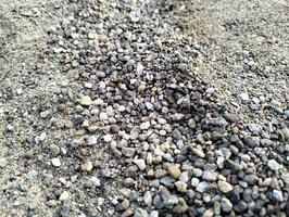 gris grava piedras para el construcción industria. montículo de granito grava, piedras, aplastada Roca de cerca. áspero sin costura textura, construcción material antecedentes. foto