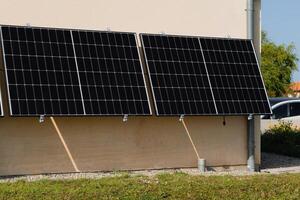 solar paneles en un bien expuesto pared de un individual casa, haciendo ahorros siguiendo el energía crisis, ciudadano ecológico gesto, verde energía foto