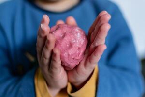 Child having fun modeling salt dough, authentic activity with natural pink coloring beet juice, fine motor skills development photo