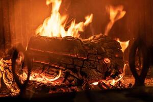 Log of wood burning in a fireplace inside a house, hearth photo