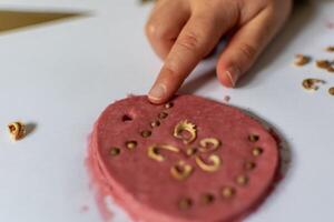 Child having fun modeling salt dough, authentic activity with natural pink coloring beet juice, fine motor skills development photo