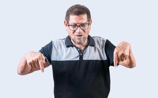 Surprised senior man pointing at a banner down. Senior old man pointing an advertisement down isolated photo