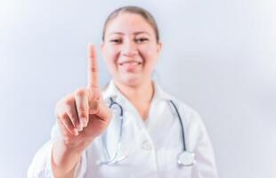 Female doctor counting number ONE isolated. Young female doctor counting number 1 on isolated background photo