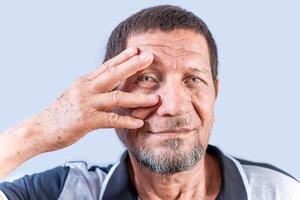mayor persona con irritado ojos. mayor hombre con ojo dolor aislado. antiguo hombre con conjuntivitis en blanco antecedentes foto
