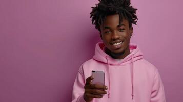 ai generado adolescente chico modelo vistiendo rosado capucha señalando a teléfono inteligente mientras utilizando móvil digital aplicaciones en Teléfono móvil. foto