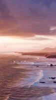 A stunning sunset over the ocean with the silhouettes of majestic mountains in the background video