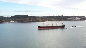 Container ship and small boat in calm sea aerial view video