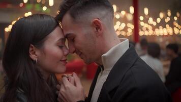 Romantic couple holding and hands and touching noses on Christmas night video