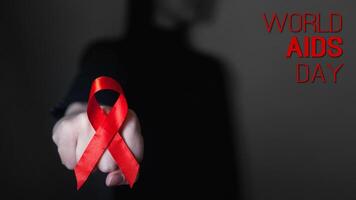 healthcare and medicine concept. Aids Awareness. red AIDS awareness ribbon on black background fist fight. text World AIDS Day. photo