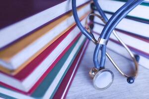 Medical student multicolor textbook and stethoscope. Collection of scientific papers photo