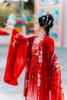 mujer vestir China nuevo año. retrato de un mujer. persona en tradicional traje. mujer en tradicional traje. hermosa joven mujer en un brillante rojo vestir y un corona de chino reina posando foto