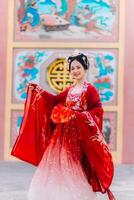 mujer vestir China nuevo año. retrato de un mujer. persona en tradicional traje. mujer en tradicional traje. hermosa joven mujer en un brillante rojo vestir y un corona de chino reina posando foto