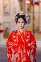 mujer vestir China nuevo año. retrato de un mujer. persona en tradicional traje. mujer en tradicional traje. hermosa joven mujer en un brillante rojo vestir y un corona de chino reina posando foto