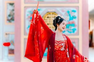 mujer vestir China nuevo año. retrato de un mujer. persona en tradicional traje. mujer en tradicional traje. hermosa joven mujer en un brillante rojo vestir y un corona de chino reina posando foto