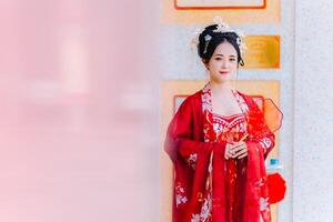 mujer vestir China nuevo año. retrato de un mujer. persona en tradicional traje. mujer en tradicional traje. hermosa joven mujer en un brillante rojo vestir y un corona de chino reina posando foto