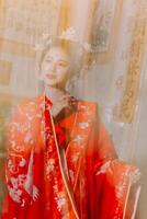 mujer vestir China nuevo año. retrato de un mujer. persona en tradicional traje. mujer en tradicional traje. hermosa joven mujer en un brillante rojo vestir y un corona de chino reina posando foto