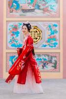 mujer vestir China nuevo año. retrato de un mujer. persona en tradicional traje. mujer en tradicional traje. hermosa joven mujer en un brillante rojo vestir y un corona de chino reina posando foto