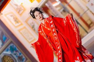 mujer vestir China nuevo año. retrato de un mujer. persona en tradicional traje. mujer en tradicional traje. hermosa joven mujer en un brillante rojo vestir y un corona de chino reina posando foto