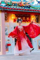 mujer vestir China nuevo año. retrato de un mujer. persona en tradicional traje. mujer en tradicional traje. hermosa joven mujer en un brillante rojo vestir y un corona de chino reina posando foto