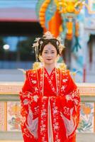 mujer vestir China nuevo año. retrato de un mujer. persona en tradicional traje. mujer en tradicional traje. hermosa joven mujer en un brillante rojo vestir y un corona de chino reina posando foto