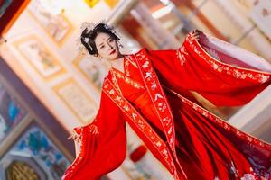 mujer vestir China nuevo año. retrato de un mujer. persona en tradicional traje. mujer en tradicional traje. hermosa joven mujer en un brillante rojo vestir y un corona de chino reina posando foto