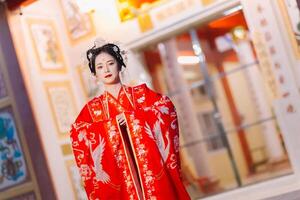 mujer vestir China nuevo año. retrato de un mujer. persona en tradicional traje. mujer en tradicional traje. hermosa joven mujer en un brillante rojo vestir y un corona de chino reina posando foto