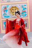 mujer vestir China nuevo año. retrato de un mujer. persona en tradicional traje. mujer en tradicional traje. hermosa joven mujer en un brillante rojo vestir y un corona de chino reina posando foto