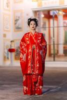 mujer vestir China nuevo año. retrato de un mujer. persona en tradicional traje. mujer en tradicional traje. hermosa joven mujer en un brillante rojo vestir y un corona de chino reina posando foto