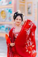 mujer vestir China nuevo año. retrato de un mujer. persona en tradicional traje. mujer en tradicional traje. hermosa joven mujer en un brillante rojo vestir y un corona de chino reina posando foto