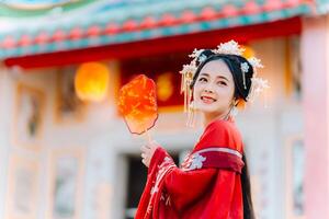 Woman dress China New year. portrait of a woman. person in traditional costume. woman in traditional costume. Beautiful young woman in a bright red dress and a crown of Chinese Queen posing. photo