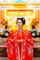 mujer vestir China nuevo año. retrato de un mujer. persona en tradicional traje. mujer en tradicional traje. hermosa joven mujer en un brillante rojo vestir y un corona de chino reina posando foto