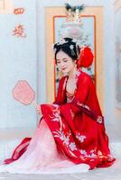 mujer vestir China nuevo año. retrato de un mujer. persona en tradicional traje. mujer en tradicional traje. hermosa joven mujer en un brillante rojo vestir y un corona de chino reina posando foto