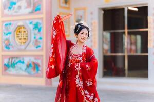 mujer vestir China nuevo año. retrato de un mujer. persona en tradicional traje. mujer en tradicional traje. hermosa joven mujer en un brillante rojo vestir y un corona de chino reina posando foto