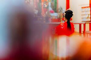 mujer vestir China nuevo año. retrato de un mujer. persona en tradicional traje. mujer en tradicional traje. hermosa joven mujer en un brillante rojo vestir y un corona de chino reina posando foto