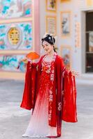 mujer vestir China nuevo año. retrato de un mujer. persona en tradicional traje. mujer en tradicional traje. hermosa joven mujer en un brillante rojo vestir y un corona de chino reina posando foto