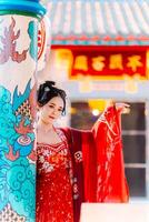 mujer vestir China nuevo año. retrato de un mujer. persona en tradicional traje. mujer en tradicional traje. hermosa joven mujer en un brillante rojo vestir y un corona de chino reina posando foto