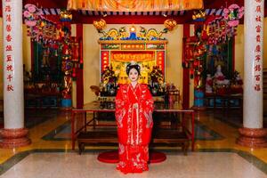 mujer vestir China nuevo año. retrato de un mujer. persona en tradicional traje. mujer en tradicional traje. hermosa joven mujer en un brillante rojo vestir y un corona de chino reina posando foto