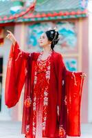 mujer vestir China nuevo año. retrato de un mujer. persona en tradicional traje. mujer en tradicional traje. hermosa joven mujer en un brillante rojo vestir y un corona de chino reina posando foto